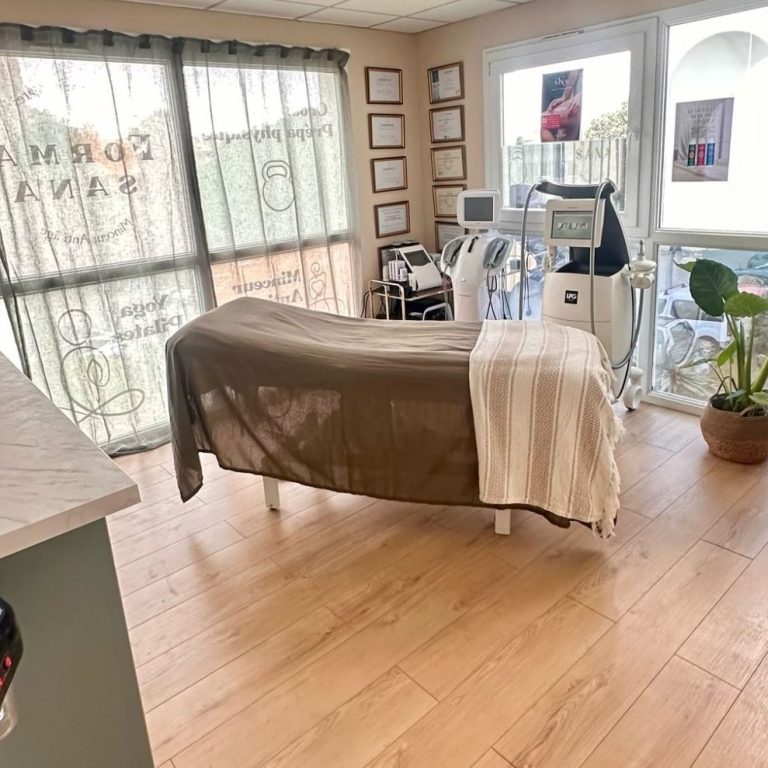 beauté minceur Cabine de soin spa avec lit, équipements esthétiques et plante en pot.